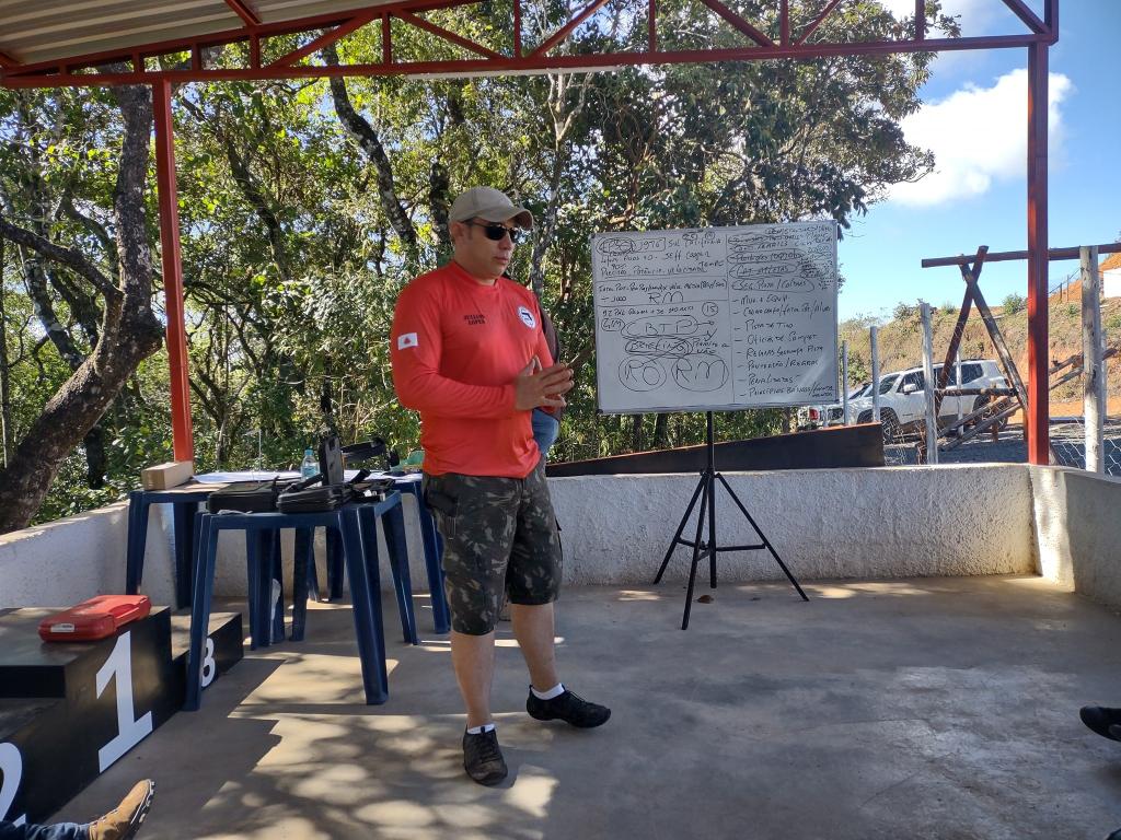 Instrutor orientando aluno na análise de alvo durante treinamento técnico